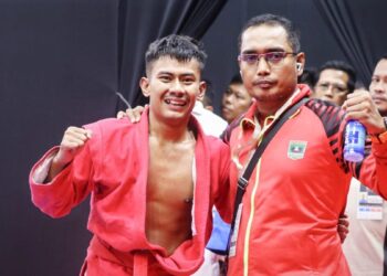 Pelatih Sambo Sumbar Hendri Gusman Darma bersama peraih emas pertama Sambo di PON Beladiri, Yusril Mahendra. (dok. Humas KONI Sumbar)