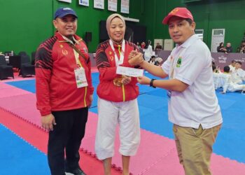 Ketua Umum KONI Sumbar Hamdanus disaksikan Wakil Ketua Umum Nurul Ikhsan menyerahkan bonus spontan kepada peraih medali emas Kempo Putri Suci Kurnia Dewi. (Foto: Humas KONI Sumbar)