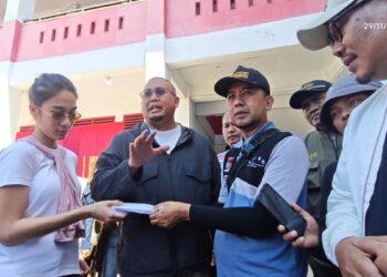 Andre Rosiade bersama anaknya Azizah Salsa serahkan bantuan untuk pengungsi banjr di Posko Pauh. (dok. Radarsumbar.com)