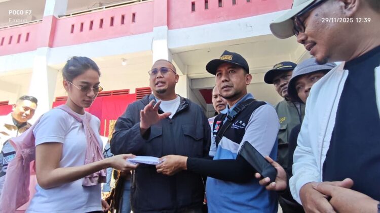 Andre Rosiade bersama anaknya Azizah Salsa serahkan bantuan untuk pengungsi banjr di Posko Pauh. (dok. Radarsumbar.com)