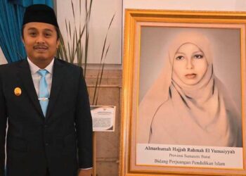 Wagub Sumbar Vasko Ruseimy berdiri disamping foto pahlawan Nasional Rahmah el Yusuniyah. (dok. adpsb)