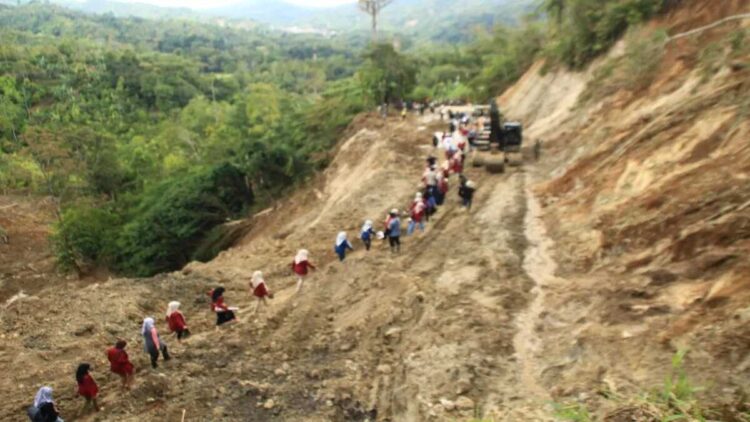 Relawan dan mahasiswa melintasi jalan Sungai Landia, Kabupaten Agam yang bertahap sudah bisa diakses setelah selama tujuh hari terisolasi karena banjir bandang dan tanah longsor. ANTARA/Al Fatah.