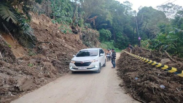 Kendaraan roda empat sedang melewati ruas jalan Kelok 44 tempatnya kelok 9 yang sebelumnya tertimbun tanah longsor dampak curah hujan. ANTARA/Yusrizal.