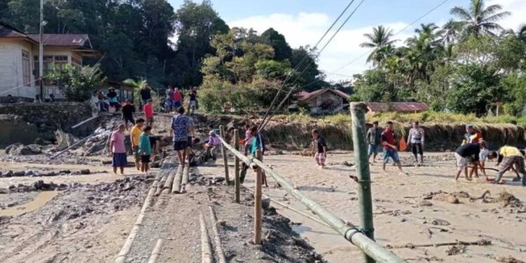 Warga Maninjau, Kecamatan Tanjung Raya, Kabupaten Agam bersama Polri dan relawan memperbaiki jembatan darurat yang dibawa arus, Sabtu (6/12). (Dok ANTARA/HO/warga)