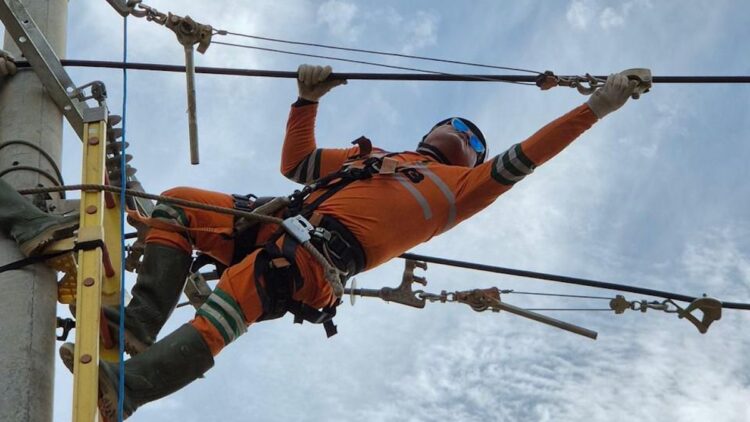 Personel PLN melakukan penarikan kabel Saluran Udara Tegangan Menengah (SUTM) di Panton Labu, Aceh Utara. (dok. Humas PLN)