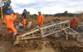 Di tengah medan yang berlumpur, petugas PLN melakukan perakitan tower darurat di jalur transmisi Langsa-Pangkalan Brandan. (dok. Humas PLN)