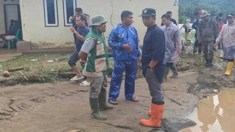 Kadis Pertanian Kabupaten Pesisir Selatan, Madrianto (sepatu orange) saat kunjungan ke salah satu lokasi terdampak banjir. (Foto: Teddy-Radarsumbar)