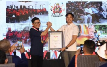 Direktur Sales dan Marketing SIG, Dicky Saelan (kiri) menerima Piagam Penghargaan Museum Rekor–Dunia Indonesia (MURI) atas Rekor Pelatihan Tukang Bangunan Serentak di Provinsi Terbanyak yang diserahkan oleh Senior Manager MURI, Triyono di Sentul, Kabupaten Bogor, Jawa Barat, pada Minggu (1/2/2026). (dok. istimewa)